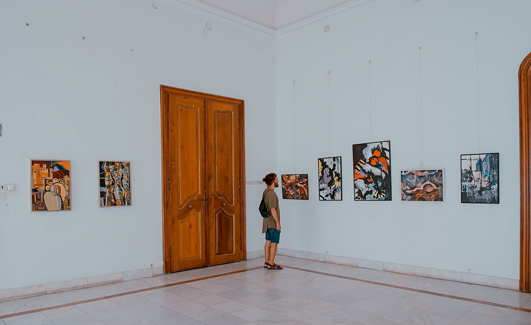 a man looking at the framed artwork on the wall at Denver Art Museum