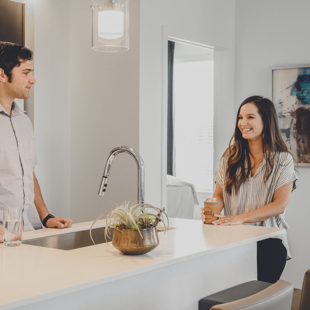 Luxury Apartments in Denver, CO - DECO Apartments Kitchen With Sleek White Countertops and Black Cabinets