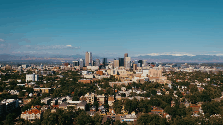 Vista del horizonte de la ciudad de Denver con las Montañas Rocosas al fondo, que ilustra el paisaje urbano de Denver y el telón de fondo montañoso.