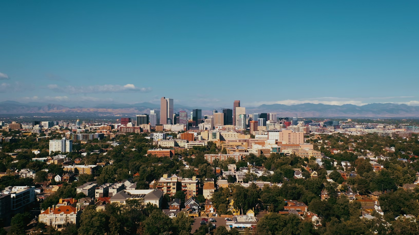 Vista del horizonte de la ciudad de Denver con las Montañas Rocosas al fondo, que ilustra el paisaje urbano de Denver y el telón de fondo montañoso.